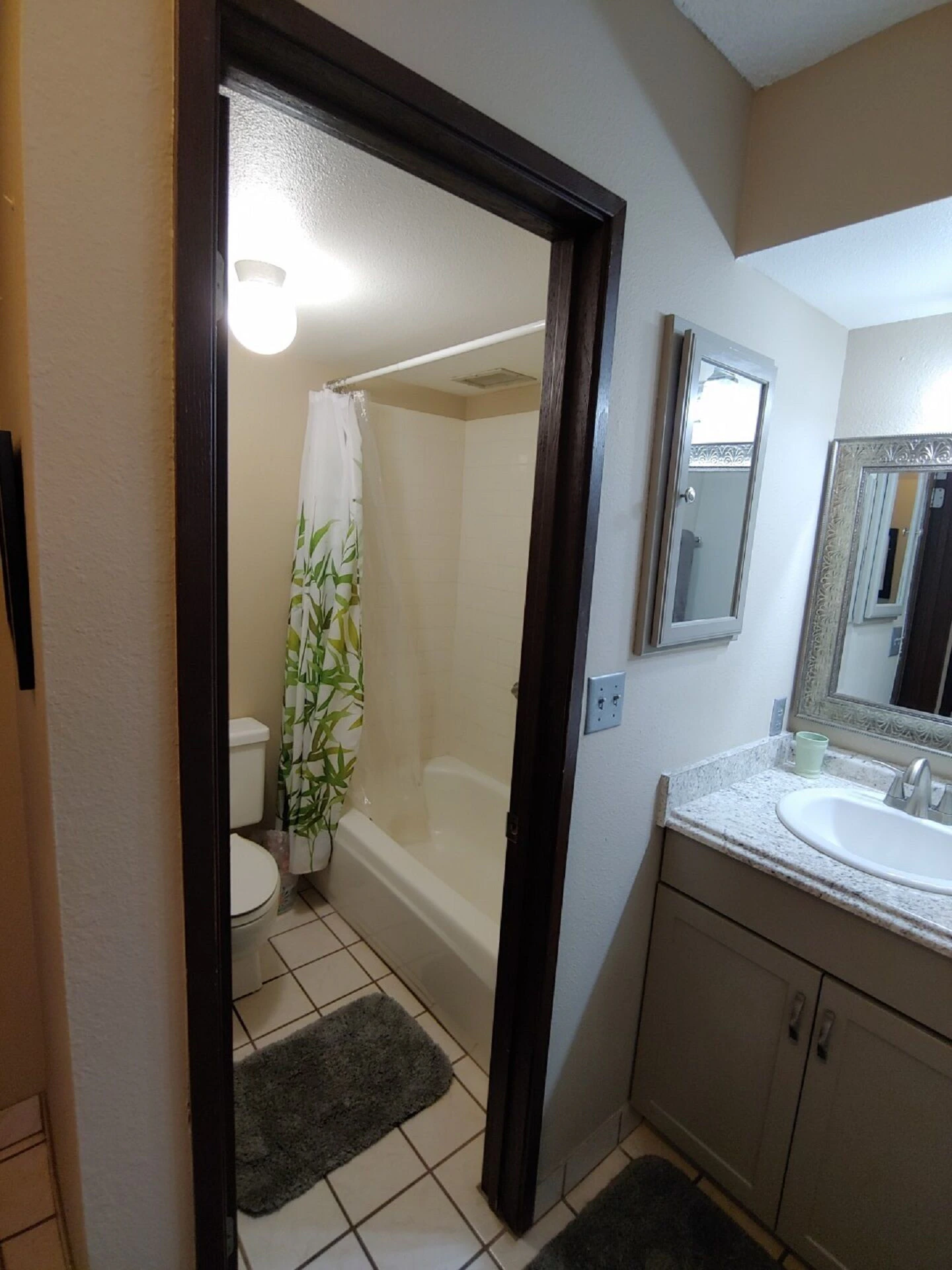Small bathroom with shower and vanity sink.