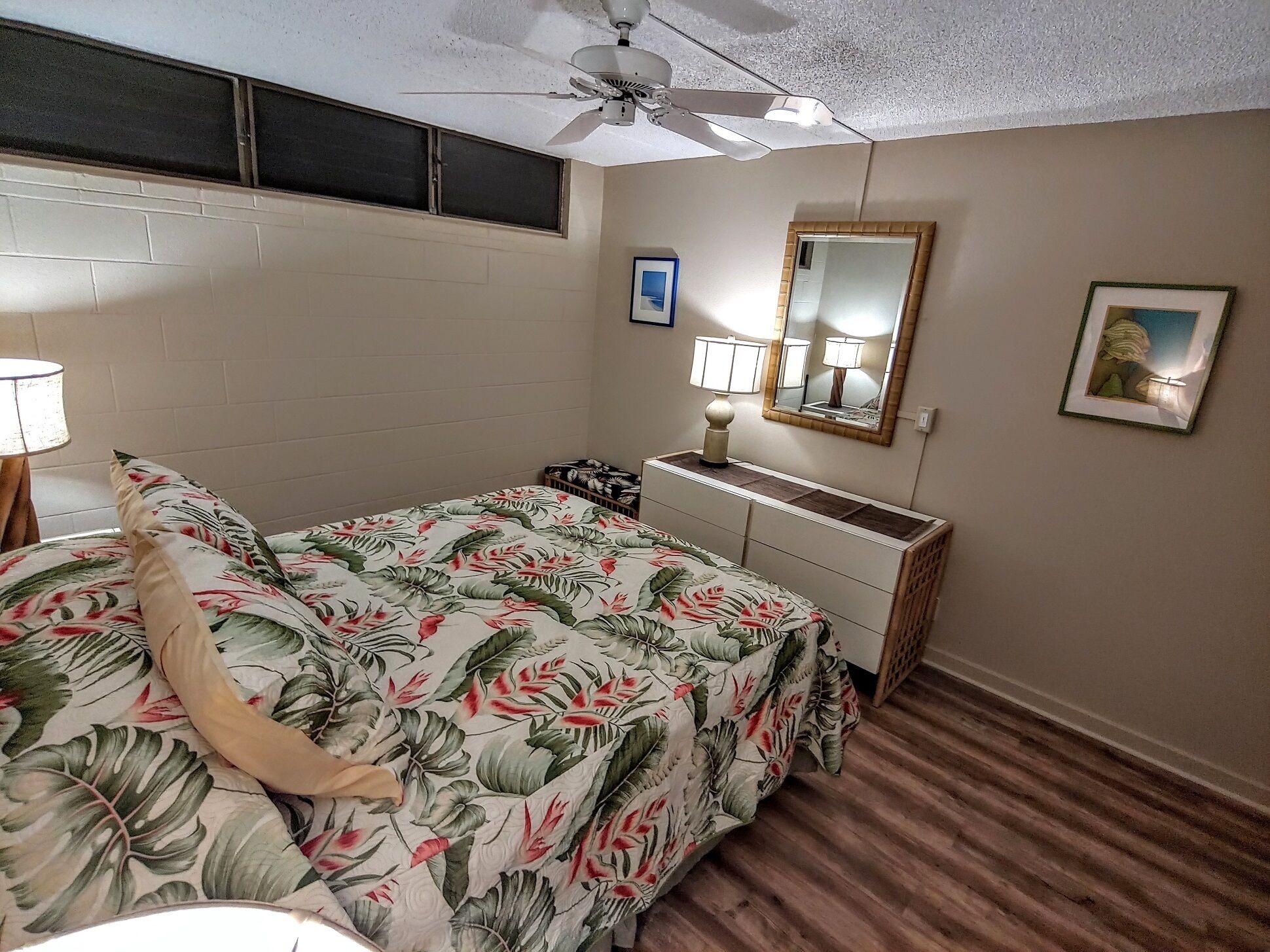 Cozy bedroom with floral bedding and artwork.