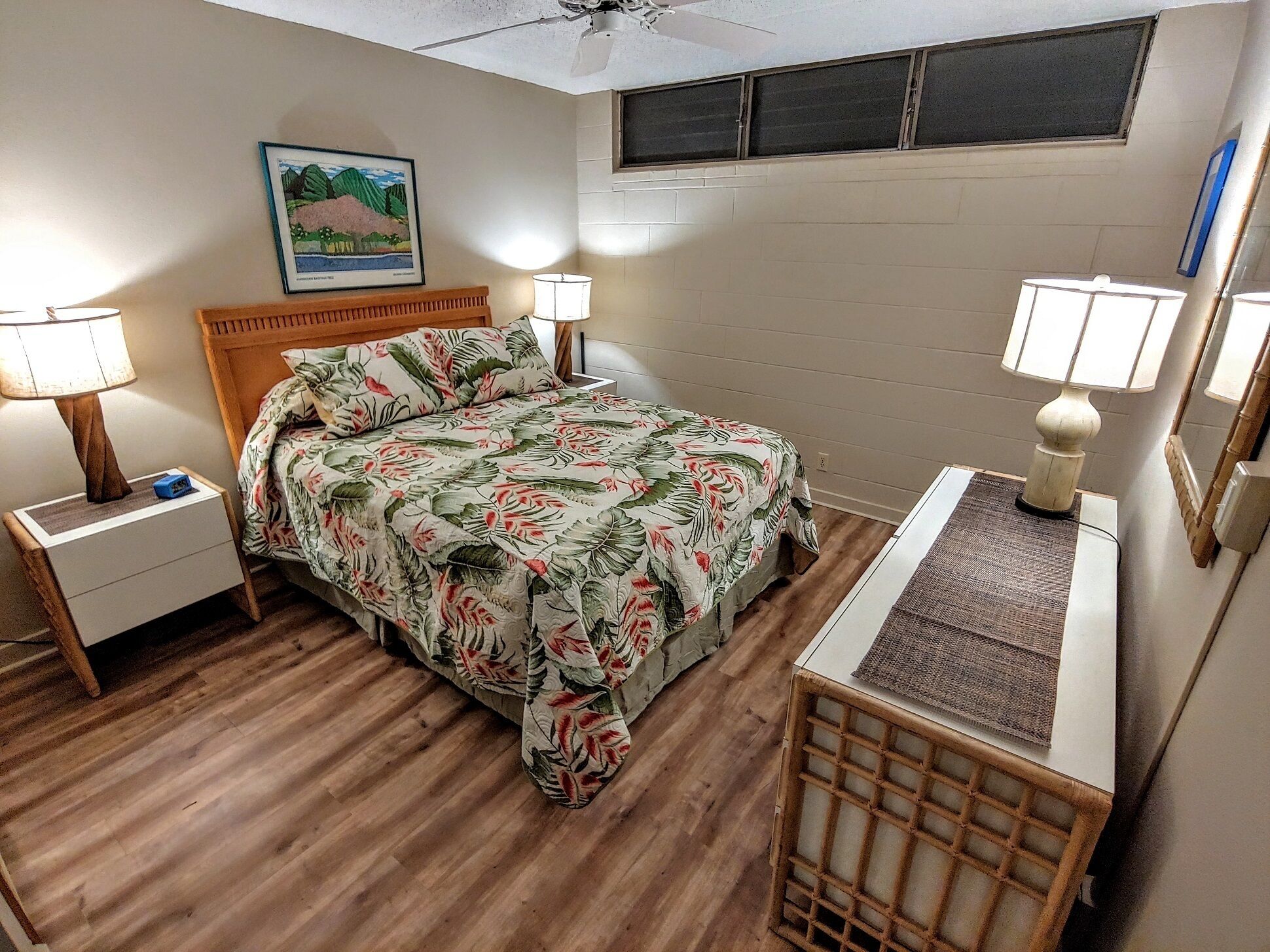 Cozy bedroom with floral bedding and wooden floors.