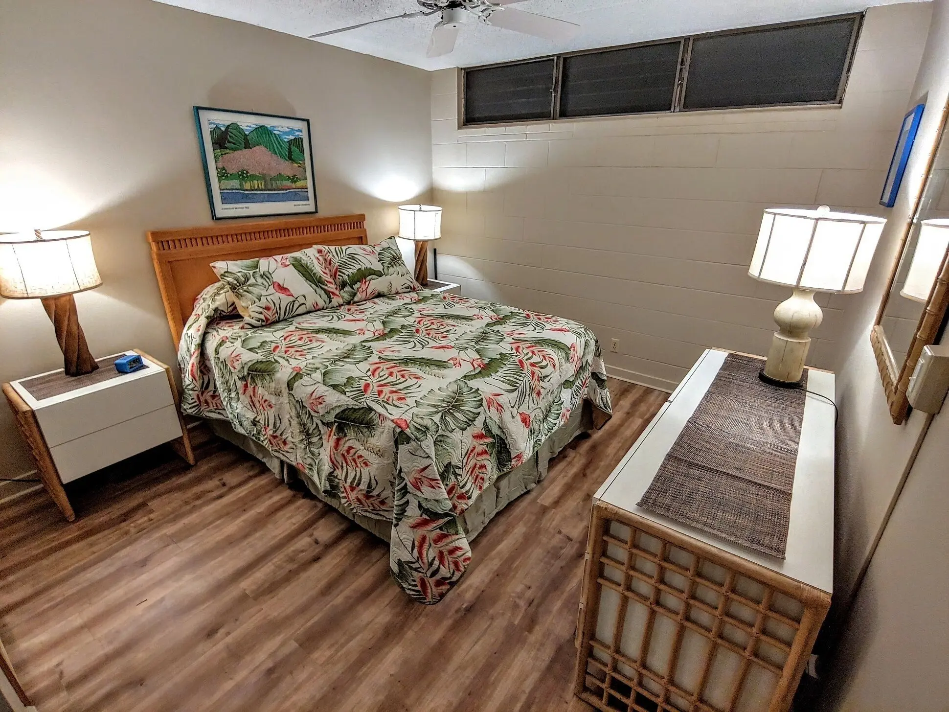 Cozy bedroom with floral bedding and wooden floors.