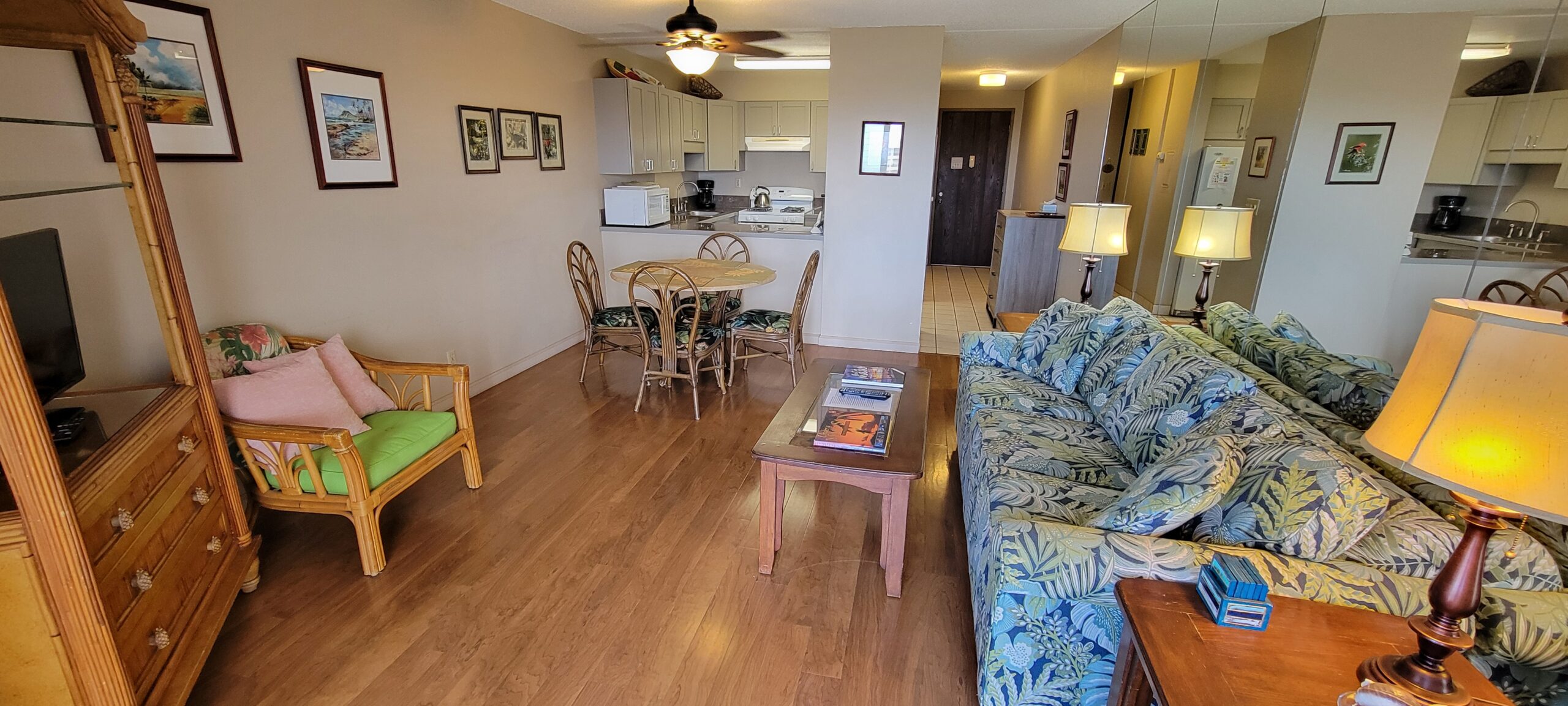 Cozy tropical-themed living room and kitchen area.